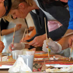 Team gestaltet abstraktes Kunstwerk beim Teambuilding mit FIRMEN MALEN