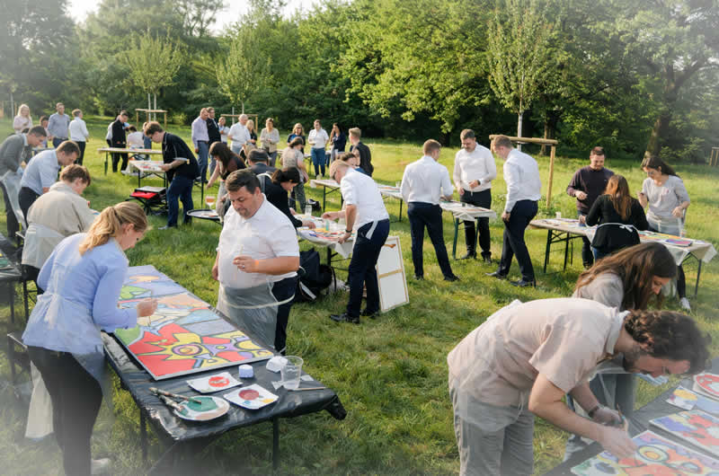 Gruppe von Mitarbeitenden beim kreativen Teambuilding in München – gemeinsames Malen mit FIRMEN MALEN