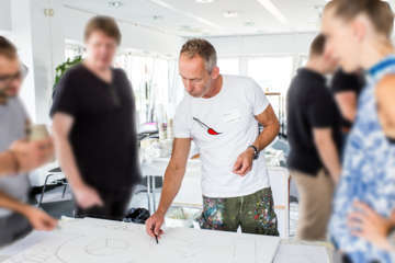 Teammitglieder arbeiten kreativ zusammen an einem großen Firmenbild