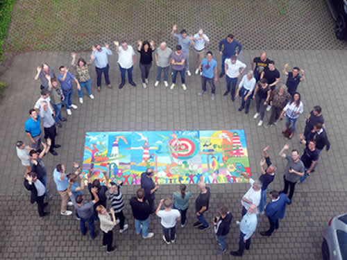 das stolze team präsentiert das beeindruckende Gemeinschaftskunstwerk